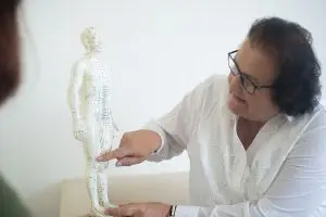 Dr. Rosmarie Seider erklärt an einer Akupunkturpuppe, wo sie die Nadeln setzen wird